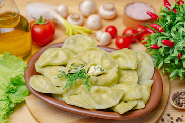 Dumplings on a wooden board with vegetables and cottage cheese