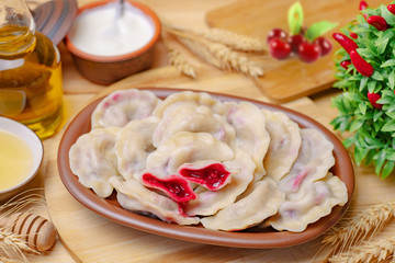 Dumplings on a wooden board with cherry