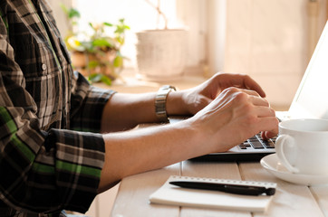 Fototapeta premium Freelancer works in the home office sitting at the desk near the window