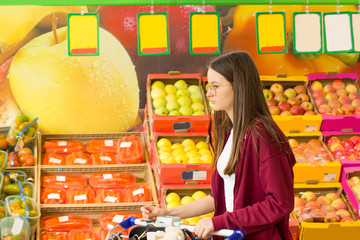 Teen girl shopping in supermarket. Young people make the conscious, organic and healthy choice.