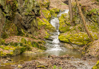 waterfall cascade between rocks in forest near stribro, long exposure