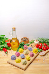 Colorful dumplings on a wooden board with vegetables