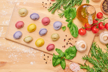 Colorful dumplings on a wooden board with vegetables