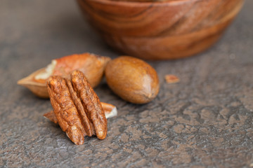 Natural pecan nuts on dark background.