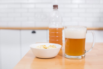 Beer mug full of beer and chips in a white plate on the white background 
