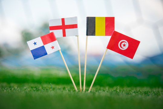 Belgium, Tunisia, England - National Flags on green football grass. Concept photo, edit space.