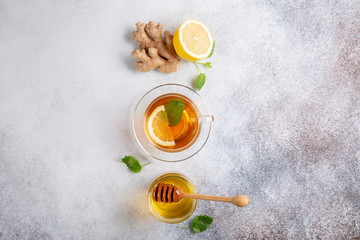 Cup of hot tea with ginger, lemon,mint and honey on concrete background. Top view. Copy space.
