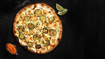 Tasty italian white pizza with seafood, made from an authentic recipe. Mozzarella topping mealted on top. Sauce and lime aside. Professional product photography and lightning.