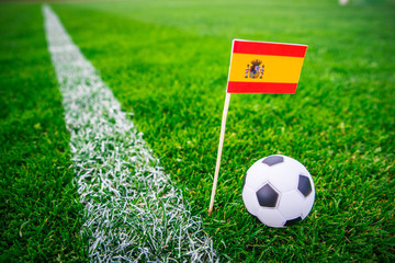 Spain national Flag and football ball on green grass. Fans, support photo, edit space