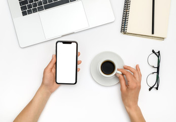 Woman is using smartphone with blank screen over white office desk