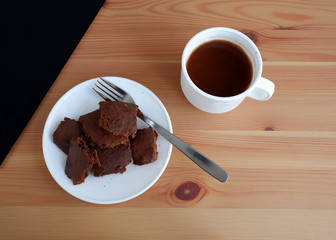 Brownie cake with a Cup of cocoa, on a wooden background
