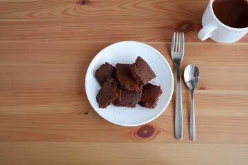 Brownie cake with a Cup of cocoa, on a wooden background