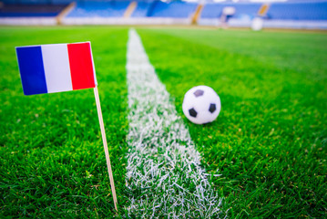 Obraz premium France national Flag and football ball on green grass. Fans, support photo, edit space