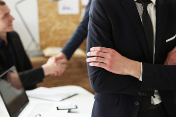 Hands of businessman at workplace crossed on chest. White collar worker at workspace shake hands,...