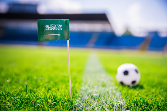 Saudi Arabia national Flag and football ball on green grass. Fans, support photo, edit space