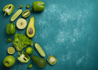 Food frame with frsh raw green fruits and vegetables on turquoise background.Top view,copy space.