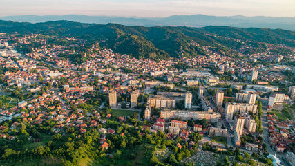 Fototapeta na wymiar Aerial view of downtown Tuzla at sunset, Bosnia. City photographed by drone, traffic and objects , landscape.city photographed from air by drone.Old balkan buildings and communism type of architecture
