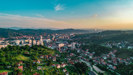 Obraz premium Aerial view of downtown Tuzla at sunset, Bosnia. City photographed by drone, traffic and objects , landscape.city photographed from air by drone.Old balkan buildings and communism type of architecture