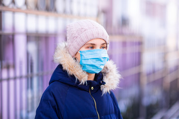Young woman wearing medical face mask to protect herself from pollution, germs and coronavirus....