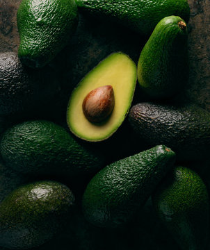 open avocado on group of avocados 