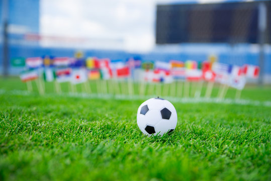 Football pitch, world nations flags, blue sky, football net in background. Sport photo, edit space.