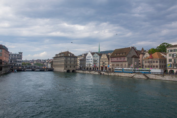 Fototapeta na wymiar Street in Zurich and quiet Limmat river waters