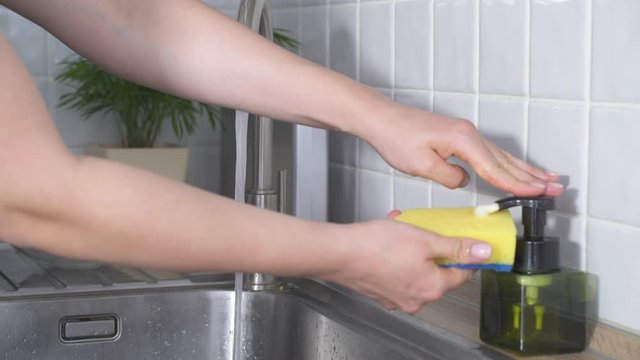 Wash pots with the sponge and gel for washing dishes in the sink.