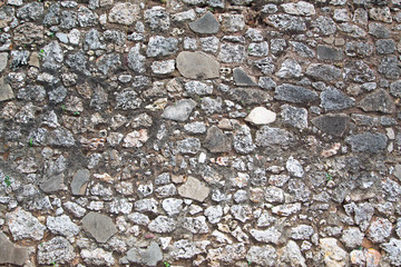 Fragment of a stone wall of stones of different, irregular shapes. Horizontal.