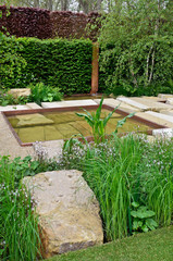 Unusual large rocks used in an urban garden design with inserted flowers and plants