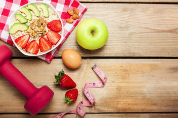 Healthy breakfast made of oats  with nuts, avocado and fresh strawberries  and fruits  on wooden  table,copy space in the middle