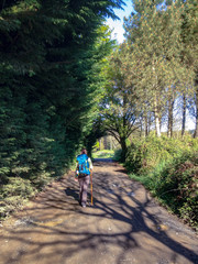  Pilgrim on the Way of Saint James, carrying her backpack through the forest