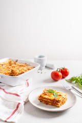 Delicious Homemade Italian Lasagna with bolognese and bachamel Sauce on white Background. Hot Tasty Lasagna with Parmesan Cheese. Restaurant menu, recipe. Side view, copy space