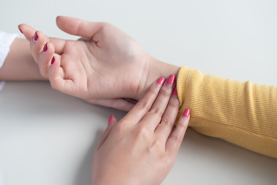 Traditional Chinese Medicine, TCM, alternative medicine woman doctor measuring pulse, testing acupressure point of patient; concept of asian alternative medicine, ancient Chinese medicine doctor