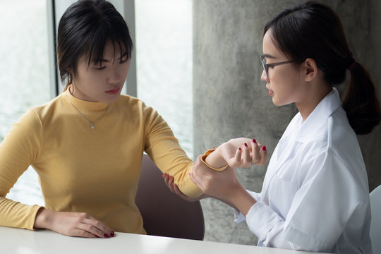 Female Orthopedic, Bone Doctor Looking Into The Arm Bone Or Elbow Joint Of Woman Patient; Concept Of Dedicated Orthopedic Surgery, Bone Doctor Test, Therapist, Medical Worker On The Job