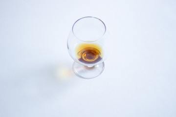 Cognac glass with trace of angel share on white background