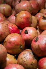 Fresh red pomegranate fruits in a crate at a farmers market.