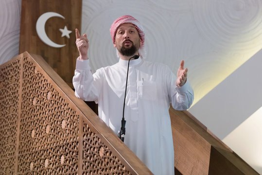 Muslims young arabic Imam has a speech on friday afternoon prayer in mosque. Muslims have gathered for the friday afternoon prayer in mosque and are listening to the speech of imam