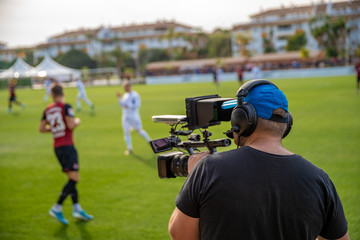 cameraman with camera shooting video on football game