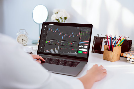 Stock exchange market concept, businesswoman trader looking computer with graphs analysis candle line on table in office, diagrams on screen.