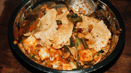 Close-up of Pecel - Traditional Javanese salad, consisting of mixed vegetables in a peanut sauce dressing, served with omelet.