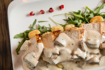 Chicken meat on grated gnocchi in cream sauce of mushrooms and smoked cheese