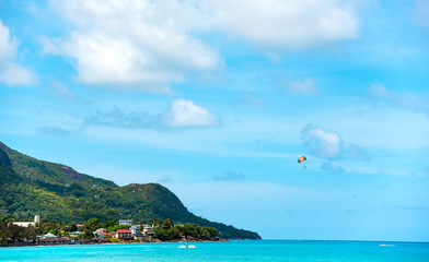 Fototapeta premium Scenic view on tropical coastline and ocean with parasailing.