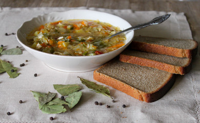 Russian Traditional cabbage, meat soup Shchi on white plate on natural wooden table background
