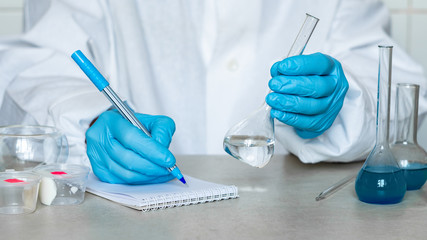 Fototapeta premium Chemist or pharmacologist examines samples of substances in a laboratory