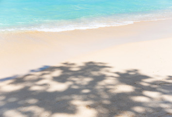 Fototapeta na wymiar Sandy beach with shadow and sea