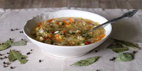 Russian Traditional cabbage, meat soup Shchi on white plate on natural wooden table background
