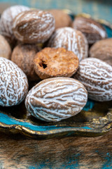 Dried nutmegs nuts in vintage bowl