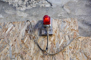 Fototapeta na wymiar bright red construction lamp lit with fence in background on entrance of construction site
