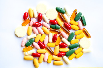 Colorful vitamin pills, tablets and softgels isolated on white background