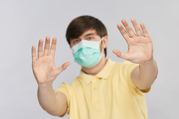 stop gesture with palms of young handsome man in yellow shirt